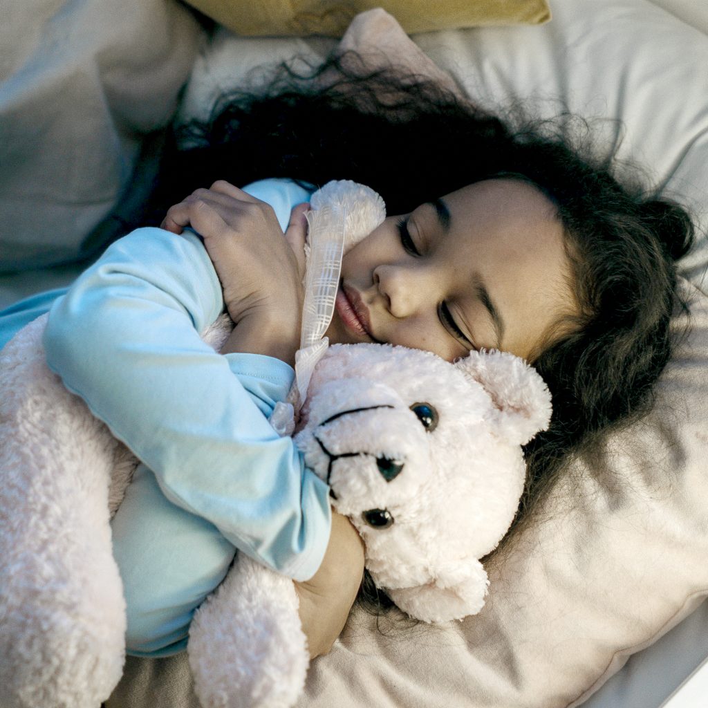 Enfant hospitalisé profitant d'un moment de réconfort auprès de sa peluche