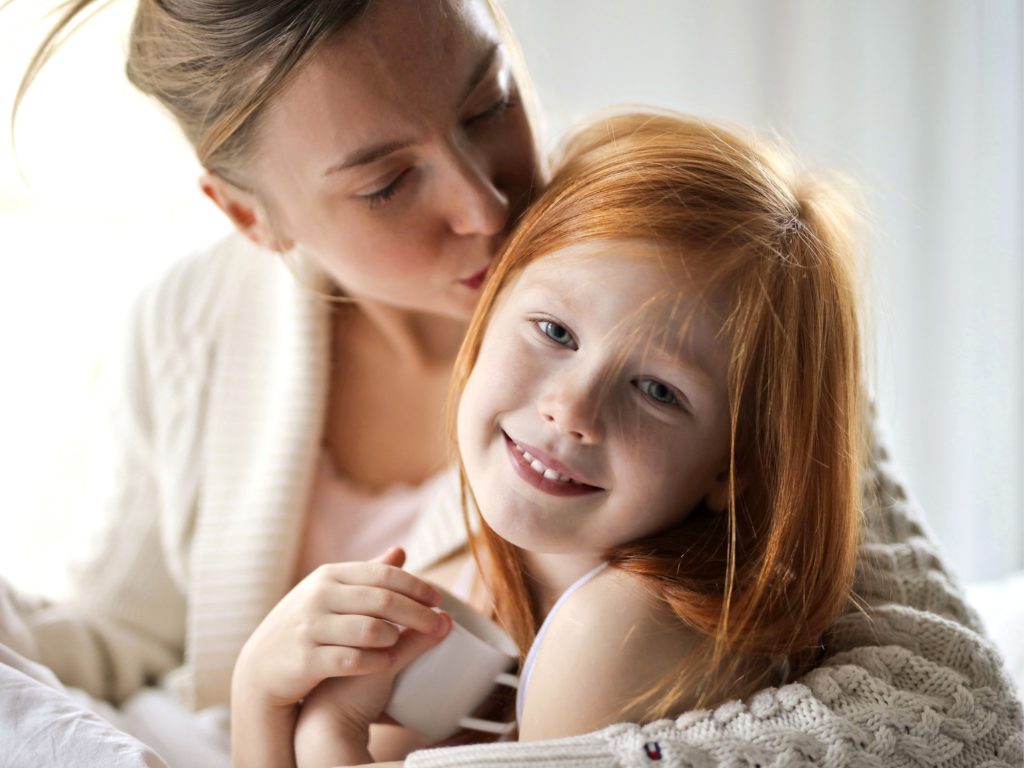 une enfant souriante dans les bras de sa mère