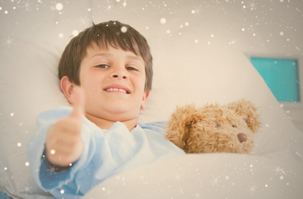 enfant hospitalisé souriant et levant son pouce