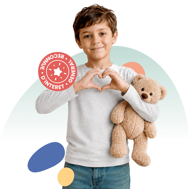 Jeune garçon format un cœur avec ses mains et tenant une peluche dans ses bras